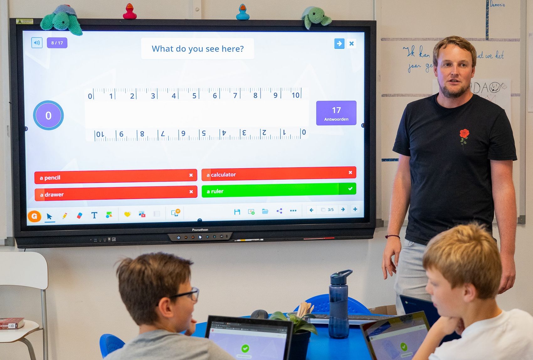 teacher quizzing students on classroom touchscreen